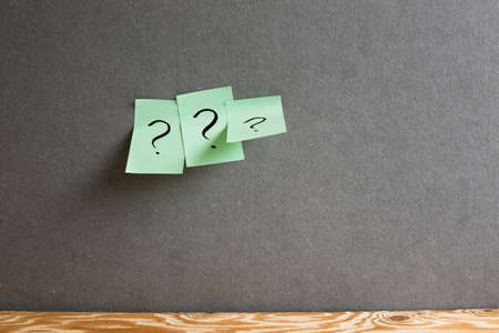 Sticky memo note paper with question mark on the gray wall. Thinking, solution, business, idea conceptの写真素材