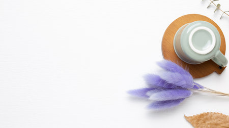 Empty mug cup with purple hares tail grass on white background. top view, copy spaceの写真素材
