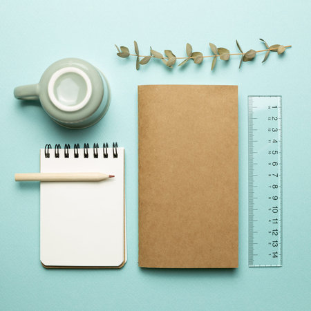 Notebook, mug cup, pencil, ruler on sky blue background. flat lay, top view, copy space. Work and...