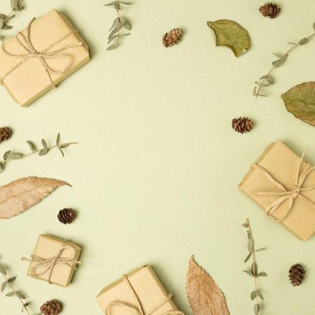 Gift boxes with eucalyptus leaves and pine cones on khaki green background. flat lay, top view, copy spaceの写真素材