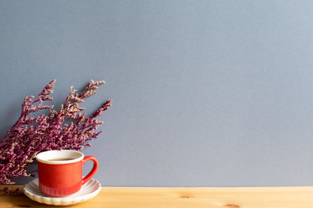 Cup of black tea with pink misty blue dry flowers on wooden tableの写真素材