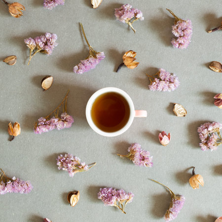 Cup of black tea with dry flowers on gray background. top viewの写真素材