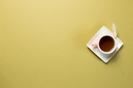 Cup of black tea on khaki green background. top view, copy space