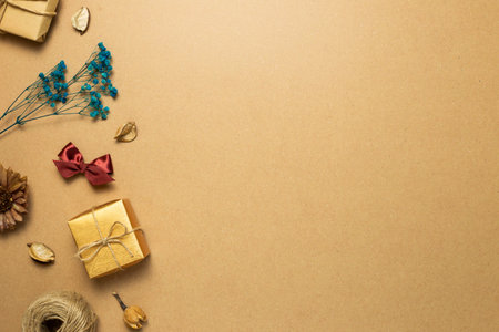 Gift box, dry flower, ribbon, string on brown kraft paper background. flat lay, top view, copy space