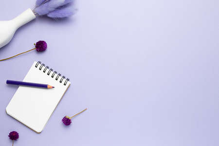 Notebook, colored pencil, dry flowers on purple background. flat lay, top view, copy spaceの写真素材