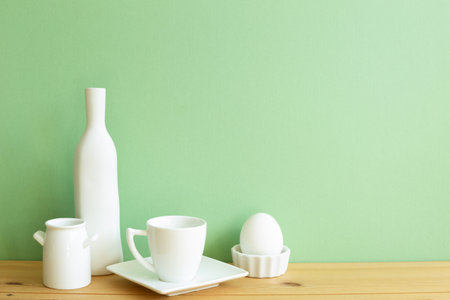 White ceramic dishware on wooden table. green backgroundの写真素材