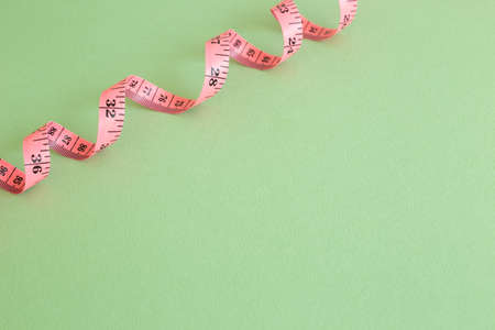 Pink tape measure on green backgroundの写真素材