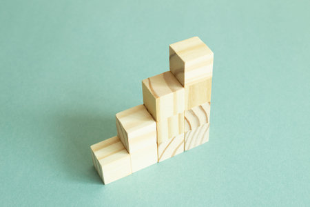 Wood block stairs on green background. Business development, growth, success concept