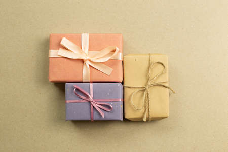 Colorful gift boxes on brown kraft paper background. flat lay, top view, copy spaceの写真素材