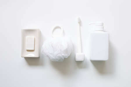 Spa bathroom products. Soap bar, toothbrush, shower ball sponge, shampoo bottle on white background. top view, copy spaceの写真素材