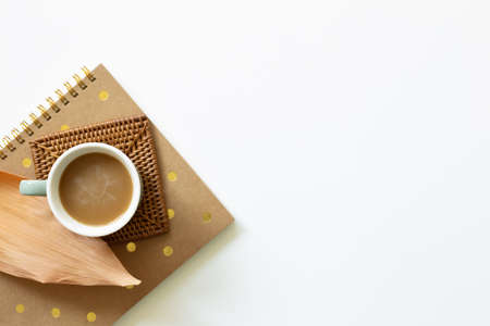 Cup of coffee and notebook on white background. Work and study place. flat lay, top view, copy spaceの写真素材