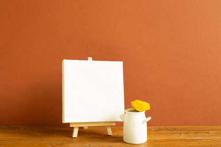 Easel with blank canvas on wooden table. brown backgroundの写真素材