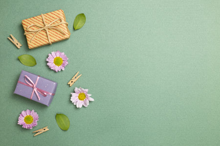 Gift boxes with flowers on green background. flat lay, top view, copy spaceの写真素材