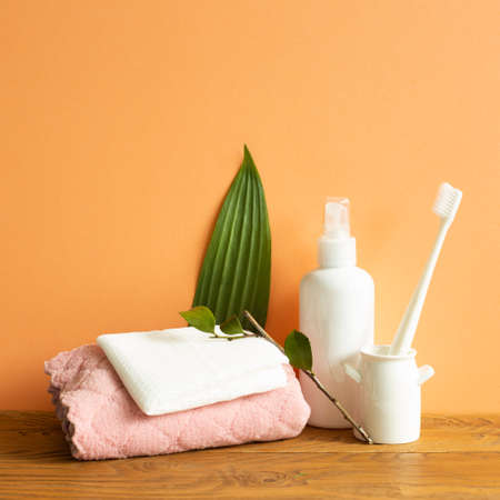 Bathroom bottle, shower towel, toothbrush on wooden table. Skin care and spa conceptの写真素材