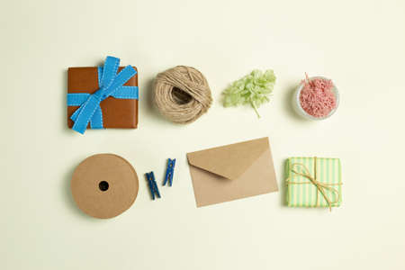 Gift boxes, ribbon string, wooden clip, envelope, dry flowers on yellow green background. flat lay, top view, copy spaceの写真素材