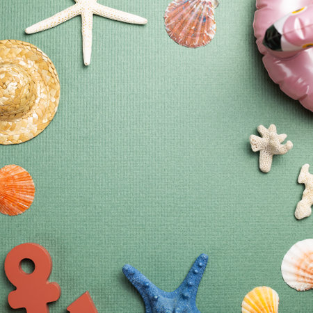 Summer vacation concept. Seashell, pink flamingo tube, straw hat, anchor, starfish on green background. flat lay, top view, copy spaceの写真素材