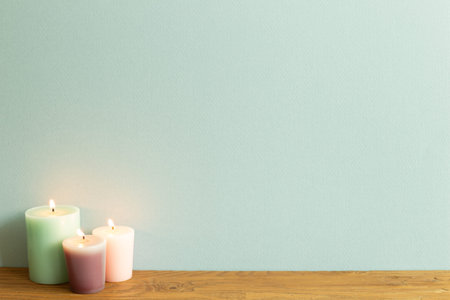 Color candles on wooden table. blue wall background. home interior