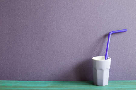 Purple cup on green wooden table. purple wall backgroundの写真素材