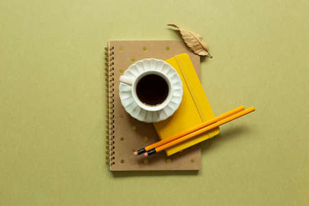 Notebook, cup of coffee, pencil on khaki background. workspace. flat lay, top view, copy spaceの写真素材