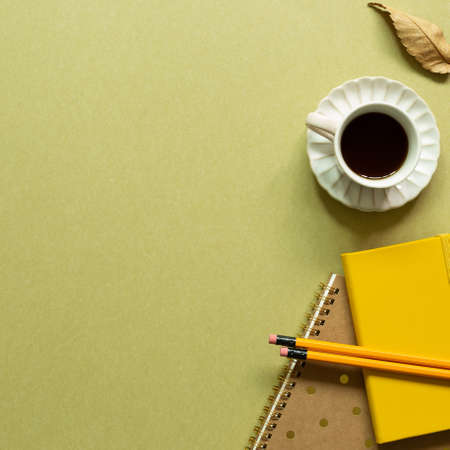 Notebook, cup of coffee, pencil on khaki background. workspace. flat lay, top view, copy spaceの写真素材
