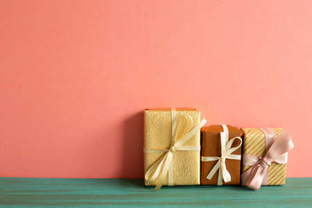 Brown gift boxes on green wooden table. pink wall backgroundの写真素材