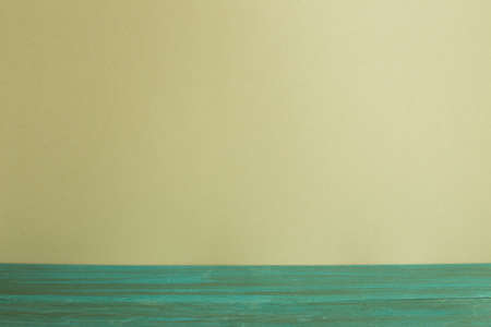 Green wooden table top with khaki wall backgroundの写真素材