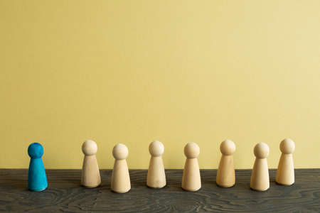 Majority vs minority concept. Wooden human figure on desk. brown backgroundの写真素材