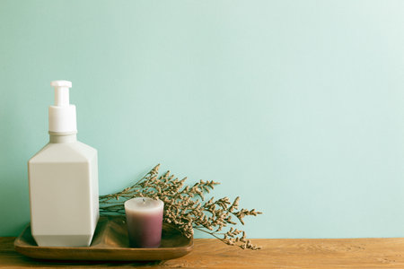 Spa beauty cosmetic bottle, aroma candle with dry flower on wooden shelf. mint wall background. home...