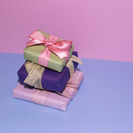 Stack of gift box on blue table. purple wall background. copy space