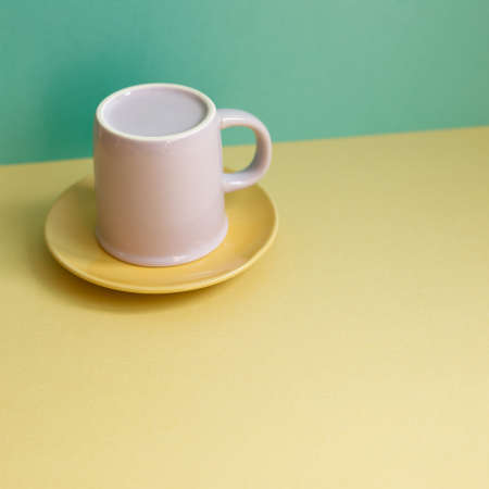 Purple mug cup on yellow table. green wall background. home interiorの写真素材