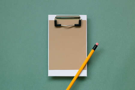 Clipboard and paper sheet on green background. top view, copy spaceの写真素材