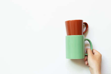 Hand holding mug cup isolated on white background. top view, copy spaceの写真素材
