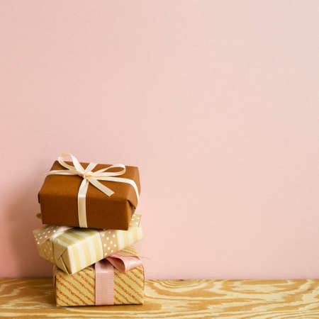Brown gift boxes on wooden table. pink wall background. copy spaceの写真素材