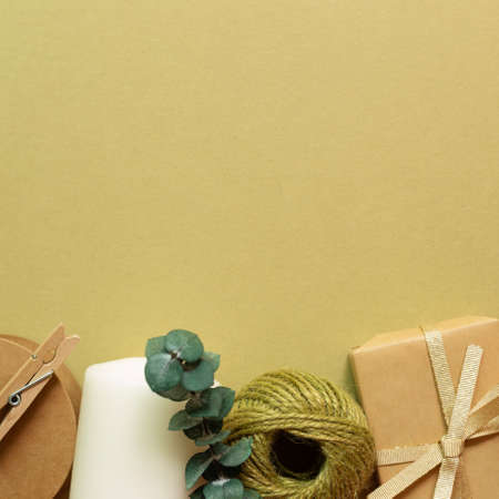 Brown gift box, string reel, candle on khaki green background. flat lay, top view, copy spaceの写真素材