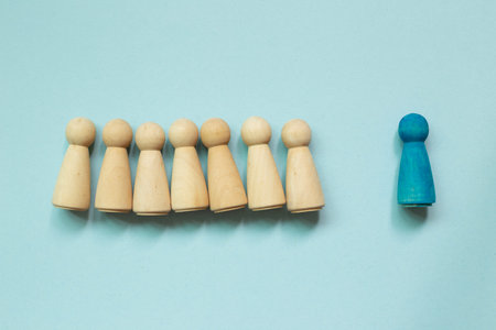 Majority vs minority concept. Wooden human figure on blue background