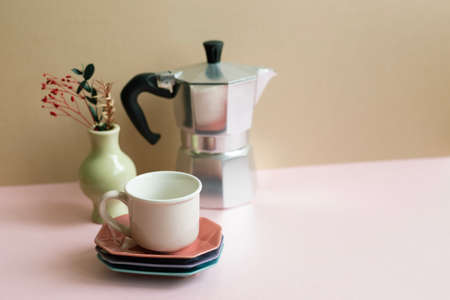 Mocha coffee pot, cup, dry flowers on pink table. beige wall backgroundの写真素材