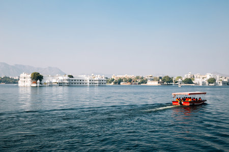 Taj Lake Palace and red boat at Pichola lake in Udaipur, Indiaのeditorial素材