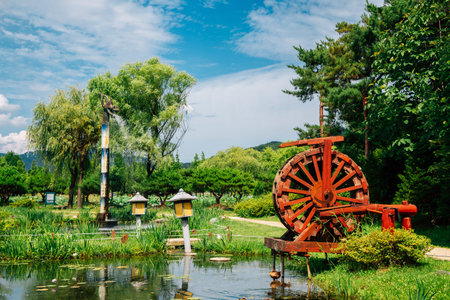 Yangpyeong, Korea - July 3, 2020 : Waterwheel and pond with green trees at Semiwon garden