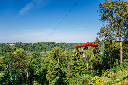 Zipline adventure activity for Cablecar Sigulda to Cablecar Krimulda with green forest mountain in...