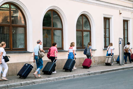Krakow, Poland - June 15, 2019: Travelers carrying suitcases at old town streetのeditorial素材