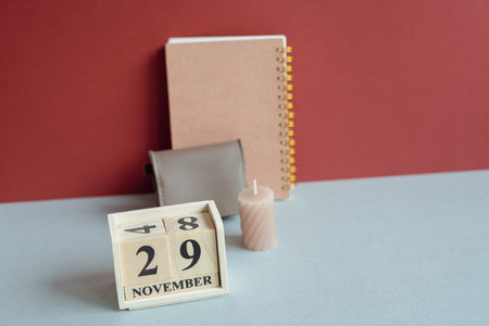 Wood calender and note, pouch, candle on desk. New year planning, schedule organizing, home office concept. red and gray backgroundの写真素材