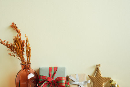 Gift boxes, vase of dry flowers, christmas ornament. ivory wall background. winter christmas, copy spaceの写真素材