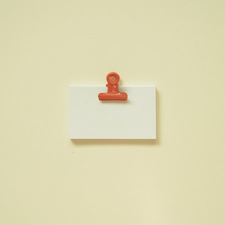 Blank white memo paper with coral clip on yellow desk background. top view, copy spaceの写真素材