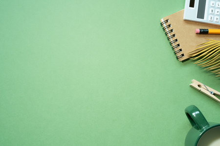 School office supplies. notebook, calculator, pencil, cup of milk on green desk background. Flat lay, top view, copy spaceの写真素材