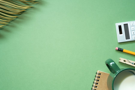 School office supplies. notebook, calculator, pencil, cup of milk on green desk background. Flat lay, top view, copy spaceの写真素材