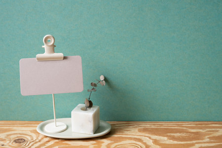 Memo card holder and plant on wooden desk. green wall background. copy spaceの写真素材