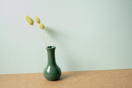 Vase of green dry flower on brown table. mint wall background. minimal, interior, copy spaceの写真素材