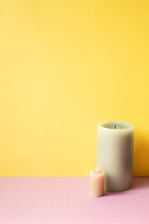 Aromatic candle on pink table. yellow background. copy spaceの写真素材