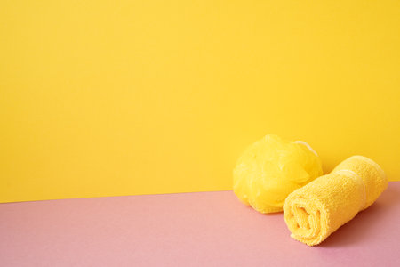 Bathroom shower ball and towel on pink table. yellow background. copy spaceの写真素材