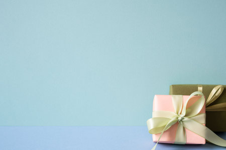 Coral and khaki gift box on blue table. mint green backgroundの写真素材